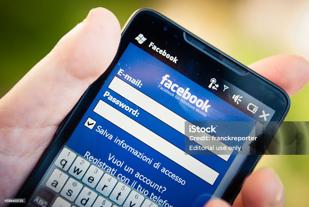 Accesso Facebook-ing su smarthphone log - Foto stock royalty-free di .com