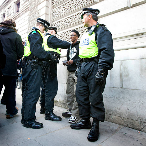 London Police stop and search London, UK - November 24, 2010: A group of three Metropolitan police officers in the act of a stop and search on a young man involved in a demonstration march in London in which UK students made their opinions clear on the government funding cuts to education fees. metropolitan police stock pictures, royalty-free photos & images