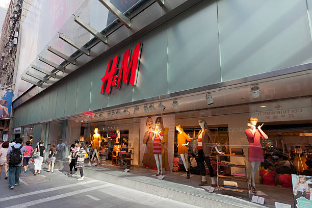 H&M fashion store in Hong Kong Hong Kong, China - August 12, 2011: Pedestrians walk past the road outside the H and M fashion store. This store is located in 68 Queens Road, Central, Hong Kong. H and M is Europe\'s second-largest clothing retailer. Some shoppers are inside the shop. h and m stock pictures, royalty-free photos & images