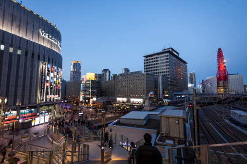 Osaka, Japan - April 1, 2012: Umeda area around the Hanku station with a view over the Yodobashi Camera building. Many pedestrians can be seen on various walkways.