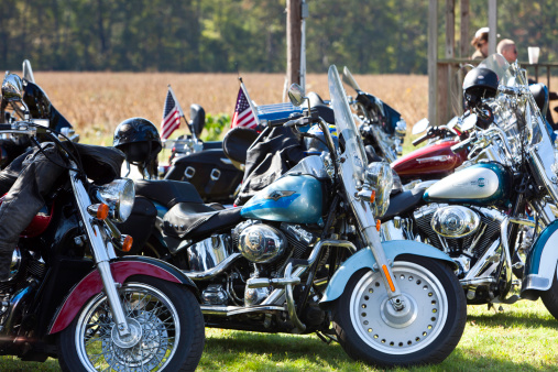 Suffolk, Virginia, USA - October 23, 2011: A horizontal shot of a row of highly polished Harley Davidson motorcycles parked in front of an open field at an outdoor rally in Driver Village, Suffolk, VA.