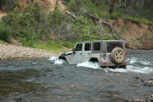 High Country, Victoria, Australia - January 7, 2009: Silver 2007 Jeep JK Wrangler Rubicon Unlimited 4 door comes out of a deep river crossing in the beautiful High Country. Famous 4wd touring area of Australia