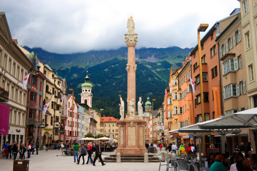 Innsbruck, Austria - 27th July, 2010: Tourists sightseeing and relaxing at the cafes nearby St Ann\\'s Column (Annasaule) at Maria Theresien Strasse (Maria Theresa street).