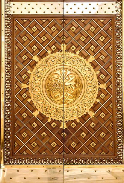 The King Abdul Azeez Gate of Prophet's Mosque, Medina Medina, Saudi Arabia - April 16, 2011: The King Abdul Azeez Gate of the Prophet's Mosque ( Masjid al-Nabawi ). There's a calligraphy in the center of the gate which says the name of the Prophet Muhammad. As the final resting place of the Prophet Muhammad, Masjid al-Nabawi is considered the second holiest site in Islam by Muslims (the first being the Masjid al-Haram in Mecca). al masjid an nabawi stock pictures, royalty-free photos & images