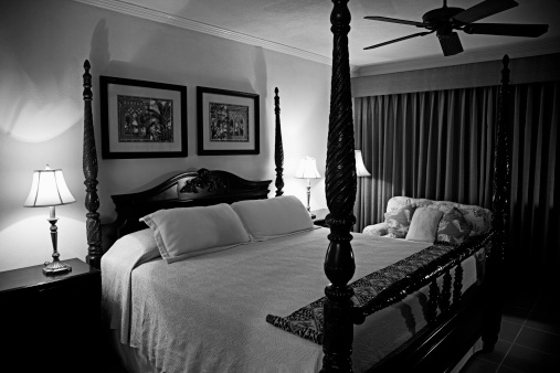 Bridgetown, Barbados - March 4, 2011: A room in The Savannah with colonial style four-poster bed and matching paintings and furnishings.