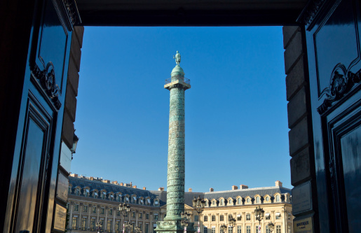 Paris, France - September 29, 2011: The Coclide column of Place Vendome seen from the entrance of a palace on the square