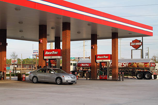 Young woman refueling car with gasoline on the gas station