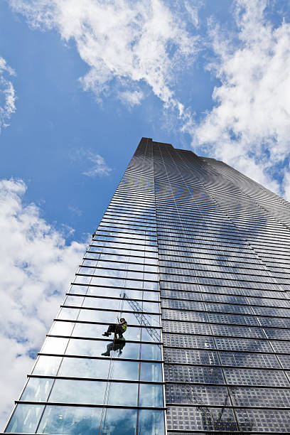 Window Cleaner on a Tall Skyscraper in Business district London, United Kingdom - July 19, 2011: A window cleaner coming down from a tall skyscraper after the end of his work in the business district. steeplejack stock pictures, royalty-free photos & images