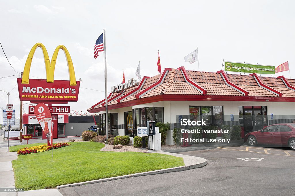 McDonald's Fast Food Restaurant Albuquerque, New Mexico, USA - July 2, 2011: Traditional-looking McDonald's fast food restaurant with the characteristic company logo pole sign. McDonalds is the world's largest chain of hamburger fast food restaurants. McDonald's restaurants are found in 119 countries around the world and serve 58 million customers each day. Approximately 15% of McDonald's restaurants are owned and operated by McDonald's Corporation directly. The remainder are operated through a variety of franchise agreements. McDonald's predominantly sells hamburgers, various types of chicken sandwiches and products, French fries, soft drinks, breakfast items, and desserts. Accessibility for Persons with Disabilities Stock Photo