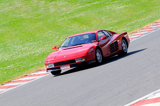 Spa, Belgium - June 29, 2008: Rec Ferrari Testarossa sports car driving around the Spa Francorchamps race track. Two persons are sitting inside the car.