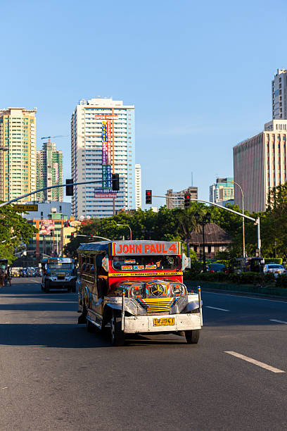 Manila, Philippines - April 19, 2012: Colourful Jeepney vehicle makes its way through traffic in Metro Manila - building in the Malate district can be seen in the background.