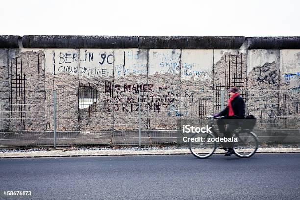 Uomo In Bicicletta Nella Parte Anteriore Del Muro Di Berlino Lato Est Germania - Fotografie stock e altre immagini di Muro di Berlino