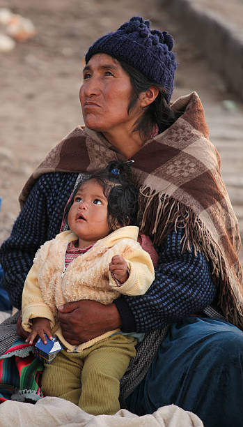 Potosi,Bolivia, December 07,2009 : A Bolivian beggar woman looks up at someone as she sits on the street with her child.