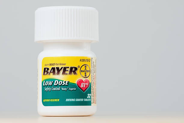 Bottle of Bayer Low Dose Aspirin Fosston, USA - February 25, 2011:  A bottle of Bayer Low Dose Safety Coated \"Baby\" Aspirin.  The bottle contains 32 Enteric Coated Tablets, 81 mg each.  Bayer HealthCare LLC. bayer schering pharma ag photos stock pictures, royalty-free photos & images