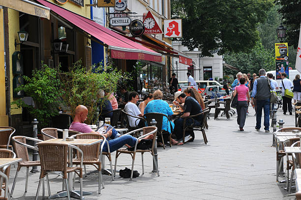 Berlin, Germany - August 3, 2011: tourists walking through Berlin Kreuzberg (Germany) at Mehringdamm, in Front small shops, restaurants. Its a touristical magnet of multi-culture.