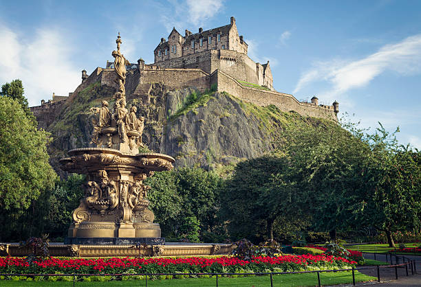Edinburgh, UK - September 18, 2012: Flowers surrounding the ornate Ross Fountain in Princes Street Gardens in Edinburgh, with Edinburgh Castle in the background.
