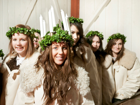 Sandviken, Sweden - December 11, 2011: Procession of girls on Saint Lucy's Day. A girl that is elected to impersonate Lucia wears a crown of candles on her head and leads the procession. They sing the song Santa Lucia and christmas carols. The candles simbolize the fire that refused to take Lucia's life when she was sentenced to be burned.