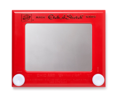 San Diego, California, United States - January 13th 2012: This is an overhead photo of a man starting to use an Etch A Sketch on a white background. The Etch A Sketch which was created in the 1950s is one of the best known toys of its generation.