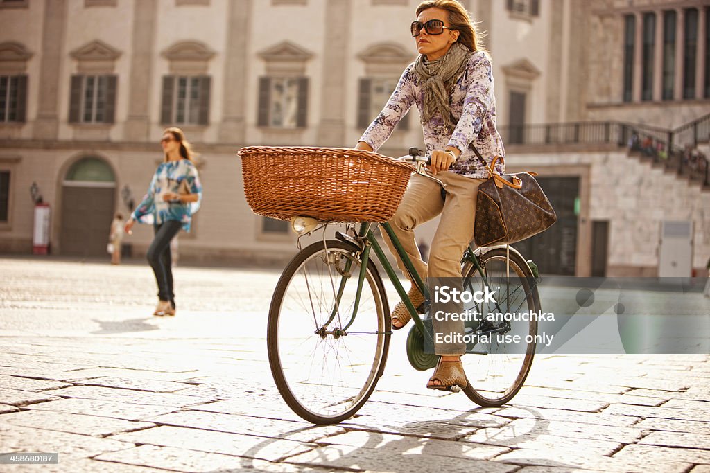 Mature Woman Cycling, Piazza del Duomo, Milan, Italy Milan, Italy - September 29, 2011: Mature Woman Cycling, Piazza del Duomo, Milan, Italy 30-39 Years Stock Photo