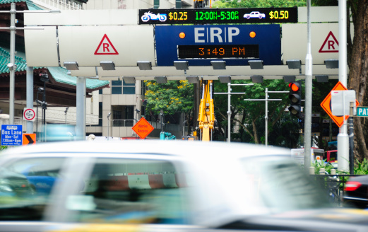 Singapore City, Singapore - March 10, 2011: ERP Gantry, Orchard Road. The image shows an Electronic Road Pricing (ERP) gantry and busy traffic in Orchard Road. The Singapore Land Transport Authority uses road pricing to manage traffic flows into the downtown district of Singapore during peak periods, Over 80 such gantries exist have been built around the city. The system was first implemented in 1998.