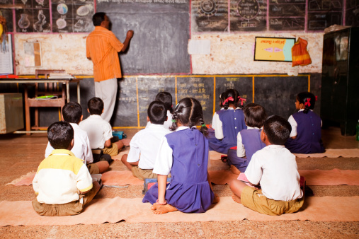 Ratnagiri, INDIA - February 20, 2010: One male teacher teaching in a rural school of India. The school is located in a village called Peve Khare Kound in Ratnagiri District of Maharashtra State.