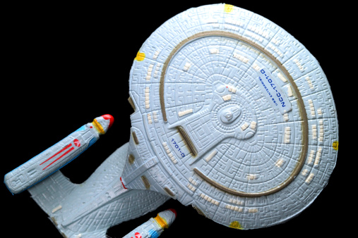 Vancouver, Canada - November 13, 2011: A model of the USS Enterprise from the  Star Trek The Next Generation television series, on a black background. The model was made by the Micro Machines division of the Galoob toy company.