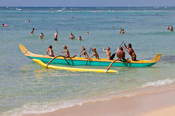 Outrigger Canoe Honolulu, Hawaii, USA - February 22, 2011: On a beautiful day at Waikiki Beach in Honolulu a group of people learn how use a Hawaiian outrigger canoe. The beach and Pacific Ocean has many tourists and locals enjoying a day at the beach. outrigger stock pictures, royalty-free photos & images