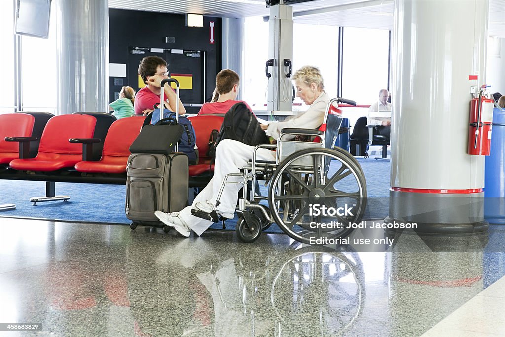 Kobieta w Wózek inwalidzki na lotnisku - Zbiór zdjęć royalty-free (Lotnisko)