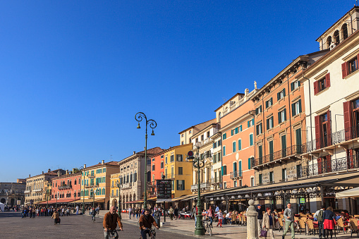 Verona, Italy - October 23, 2012: People strolling and cycling on the Liston and in Piazza Bra. These are among the favorite places of Veronese people and tourists to meet up and walk, in front of the Arena, which stands on the other side of the square.