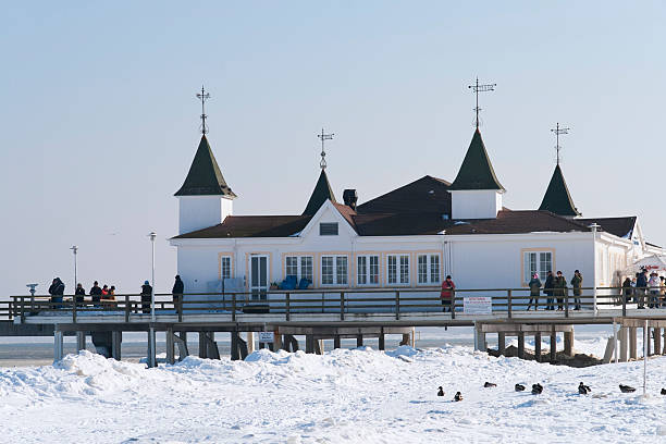 Ahlbeck, Germany - February 6, 2010: Winter on the Baltic Sea in Ahlbeck. The building on the entrance of the long promenade pier is a special kind of an ancient pavilion from the 19th century. Today it is a restaurant. It is typical pleasure pier for tourists on the Baltic Sea. The attraction was the very snowy beach on the Baltic Sea.
