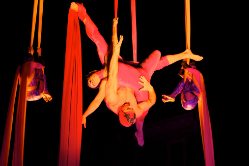 Imola, Italy - June 12, 2009: acrobats team performs with fantasy dress in the town square of the city of Imola during a outdoors free circus spectacle at night with arctificial lights. The spectacle, is a part of a series of free summer spectacles organized by the municipality. Imola, Emilia-Romagna, Italy.
