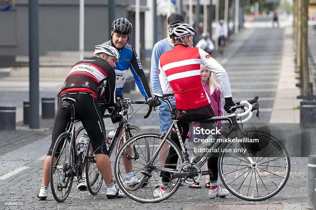 Riders are relaxing before a bike ride Taastrup, Denmark - May 29th, 2011: A couple of guys are relaxing before going for a bike ride in Taastrup, a suburb to Copenhagen. They are all wearing helmets and they are holding on to their expensive racing bicycles. Active Lifestyle Stock Photo