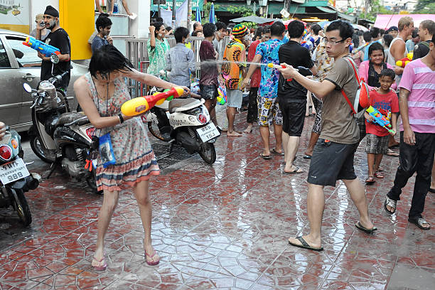 Thai New Year Celebrations "Bangkok, Thailand - April 13, 2012: Revellers participate in a water fight in celebrating the Thai new year on a city street in the Thai capital. The new year celebrations are held from 13 to 15 April." khao san road stock pictures, royalty-free photos & images