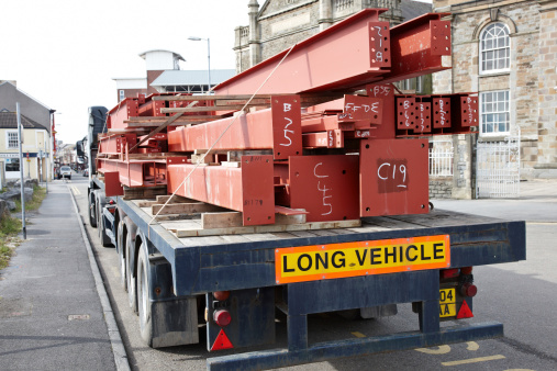 Llanelli, Wales - March 14, 2011: Large lorry delivering heavy steel girders to building site. Vehicle parked in Upper Park Street in the town of Llanelli