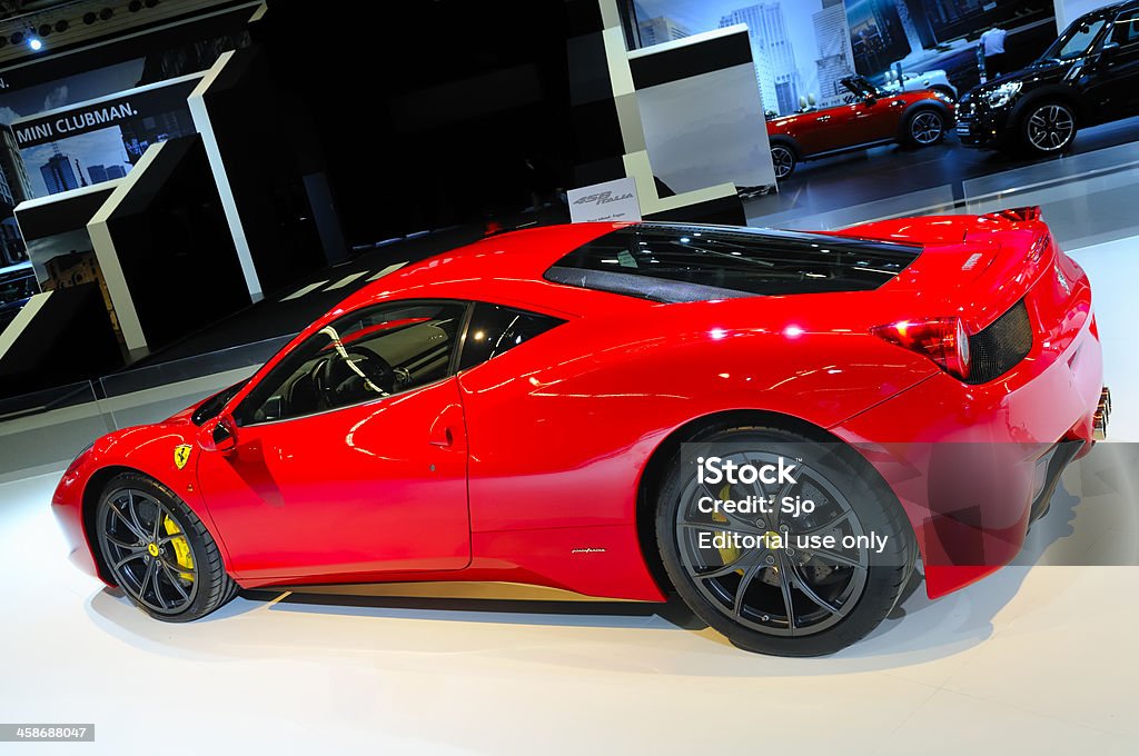 Ferrari 458 Italia sports car rear view at motor show Amsterdam, The Netherlands - April 12, 2011: Red Ferrari 458 Italia on display at the 2011 edition of the Amsterdam motor show. People in the background are looking at the cars. The Amsterdam motor show was held from April 12 until April 23 in the RAI convention center. Business Stock Photo