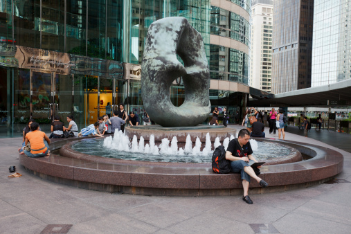 Hong Kong, China - August 12, 2011: People around the Eight Statue in front of the Hong Kong Stock Exchange Building. Hong Kong Stock Exchange is located in Exchange Square, Central District, Hong Kong.