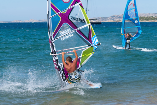 Porto Pollo, Sardegna, Italy-15th August 2010. Strong winds with small waves are the perfect conditions for freestyle windsurfers enjoying their holidays in North Sardegna (Italy). In this shot, a young windsurfer right at the end of a \\'vulcan\\' manouvre.