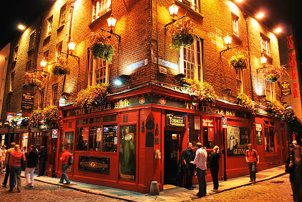 Temple bar by night, Dublin, Ireland "Dublin, Ireland, August 3rd 2008 - View of Temple Bar by night. People standing in front of the pub in an area of Dublin famous for the nightlife" guinness photos stock pictures, royalty-free photos & images