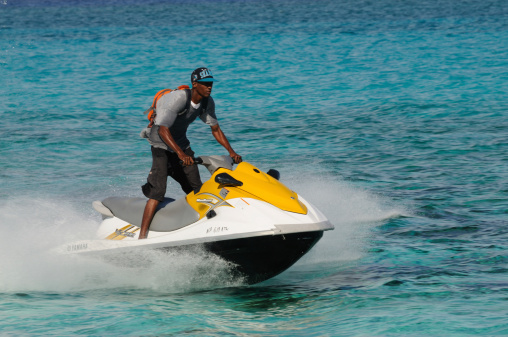 Nassau, The Bahamas - January 10, 2012: A jet ski at speed, off Paradise Island, Nassau, in the Bahamas. Ridden by an unidentified Bahamian, on his way to offer the jet ski for hire on the beach at the Atlantis Resort.