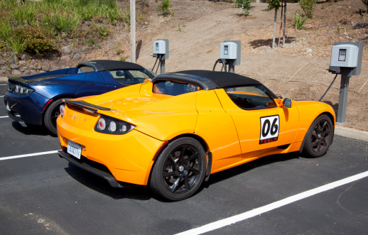 Palo Alto, California, USA - July 19, 2011: Two convertible Tesla Roadster electric sports cars being charged in a parking lot. The Roadster was designed in partnership with Lotus and debuted in 2008 and had a sticker price of around $100,000 dollars. Tesla plans to continue to sell the cars through 2012.
