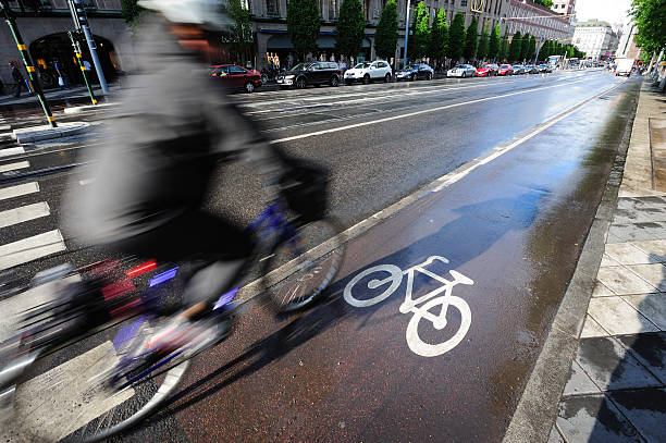 vélo sur piste cyclable - blurred motion street car green photos et images de collection