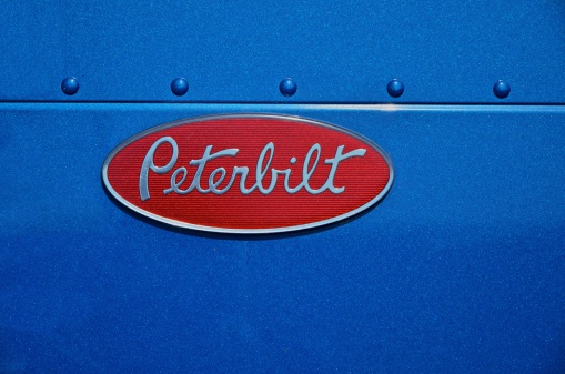 Cincinnati, Ohio, USA - July 31 2011: Oval Peterbilt badge on the hood of a blue American-built Peterbilt semi truck cab