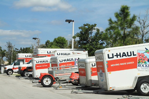 West Palm Beach, USA - February 22, 2012: A row of U-Haul trucks and trailers are parked in a storage lot. There are several U-Haul trucks and various size trailer units. U Haul is a large moving and storage rental company in the USA.