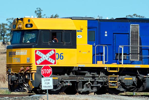 Australian coal train passing through country road crossing stock photo