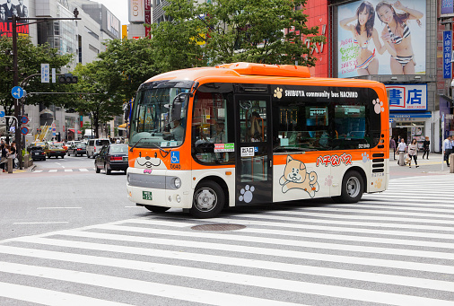 Tokyo, Japan - May 30, 2011: The Shibuya Community Bus, nicknamed the Hachiko Bus, crosses the intersection at the Shibuya Crossing in front of the Shibuya Station Hachiko exit in the Shibuya Ward of Tokyo.