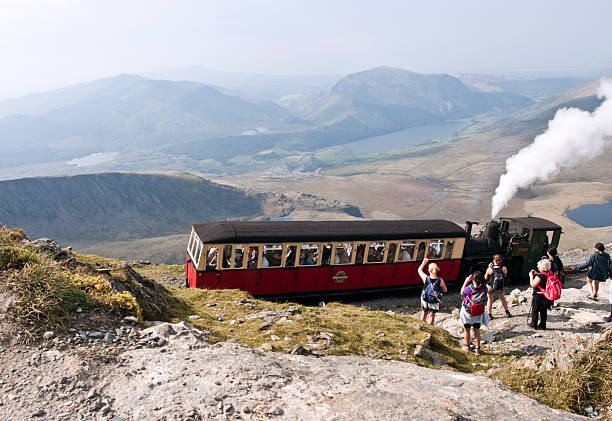 Steam train, Snowdon mountain, Wales! UK "Mount Snowdon, North Wales - March 2, 2011, view of steam train leaving the summit And a group of people waving it goodbye" mount snowdon photos stock pictures, royalty-free photos & images