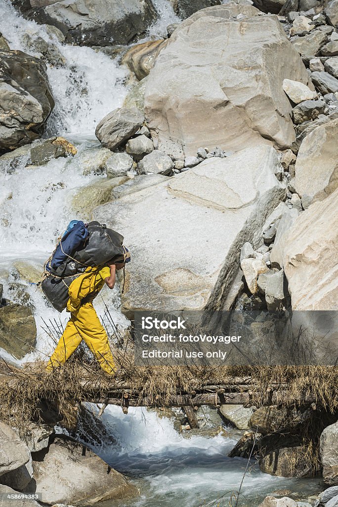 Sherpa porter Carregando expedição kit de montanha, rio, Himalaia Nepal - Foto de stock de Adolescente royalty-free