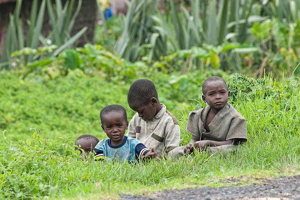 Kibati in North Kivu, Democratic Republic of Congo - Ocotber 27, 2007: A group of young african children is sitting on the roadside, they are curious and shy looking  into the direction of foreign visitors. Location: Kibati village, close to the town of Goma in North Kivu, Democratic Republic of Congo.