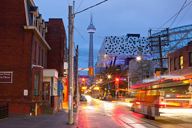 Toronto, McCaul Street "Toronto, Canada - September 27, 2009: Ontario College of Art (OCAD) and the expansion of 2004, the modern Sharp Centre for Design by architect Will Alsop. Ontario College of Art is Canada's largest and oldest institution for art and design. CN Tower in the background seen through the McCaul Street at a rainy september afternoon. Streets are wet and reflecting the lights of the vehicles passing by. An interesting architectural mix between the old bridgstone houses on the left and the modern architecture of the Sharp Centre of Design." ocad stock pictures, royalty-free photos & images