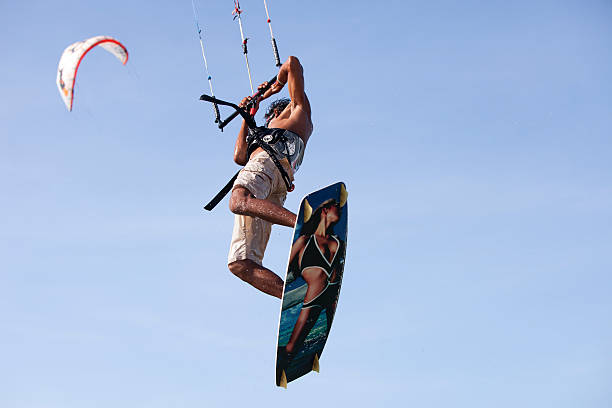 Jericoacoara, Brazil - November 19, 2011: Young man kite surfing in a lagoon of Jericoacoara. Kite surfing is a very popular sports activity in Jericoacoara. There are lots of kite surfing school that serves to the visitors who are interested in learning this fantastic sport. Sometimes kite surfer can jump 5-10 meters with the help of the kite and wind. This image has been captured while kite surfer jumping.